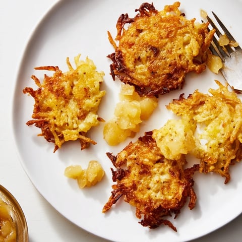 Klassische knusprige Kartoffel-Latkes serviert mit süßer hausgemachter Apfelsoße.