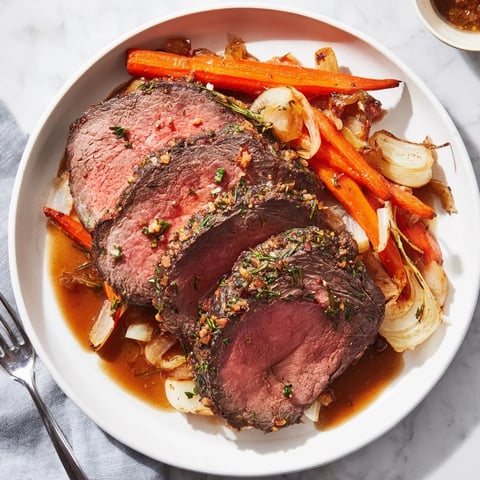 Saftiger Festtagsbraten mit frischen Kräutern und Knoblauch, ideal für Feiertagsfeiern.